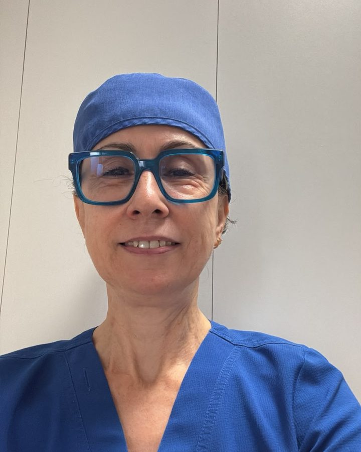 La Dra. Gema Rojo en la clínica, con uniforme azul y gafas